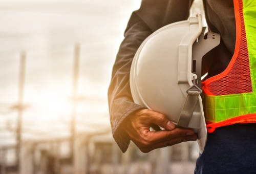 Technician holding white hat safety hard hat sunlight background Technician holding white hat safety hard hat sunlight background