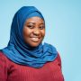Portrait beautiful smiling muslim woman wearing traditional hijab isolated on blue background. Happy religious African American student looking at camera, education concept